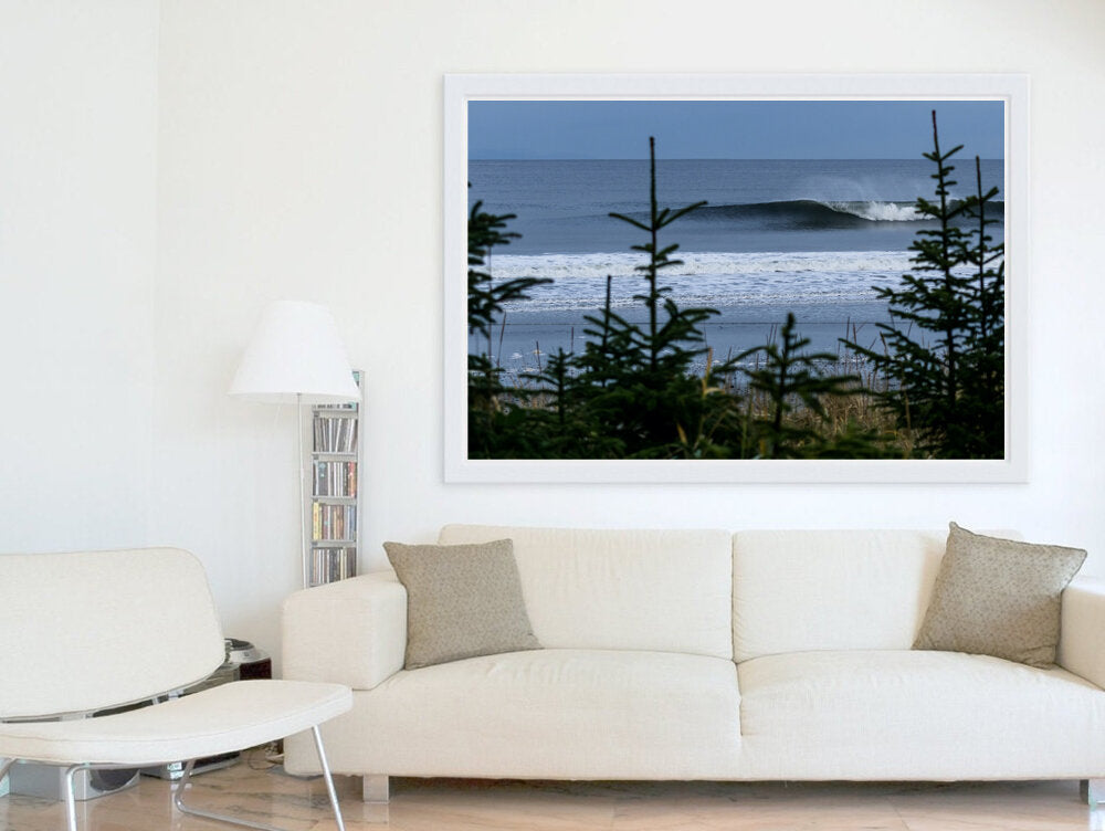 Beyond the Pines- A photograph by Mark McInnis in a white frame above a couch.