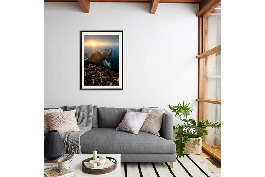 A Southern Dawn- A photograph by Mark McInnis in a black frame above a grey couch.