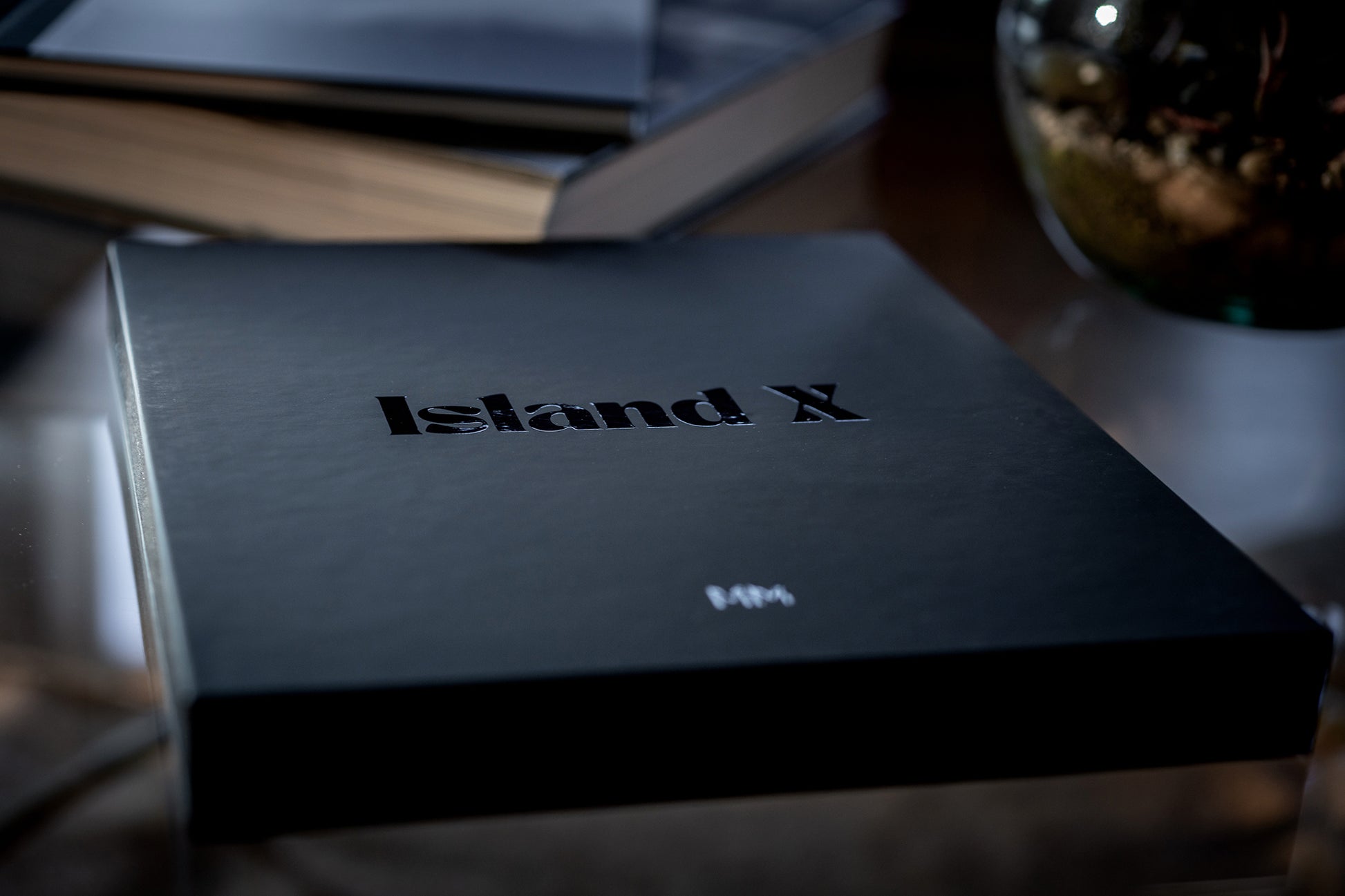 Island X- A photography book by Mark McInnis- Limited edition black slip case on a table.