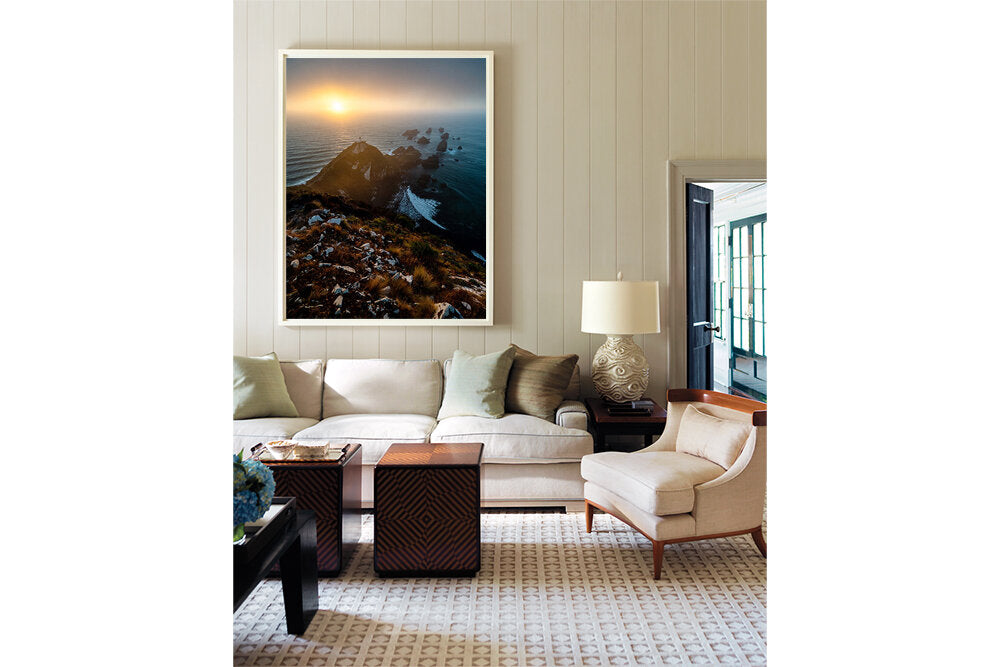 A Southern Dawn- A photograph by Mark McInnis in a white frame above a couch.